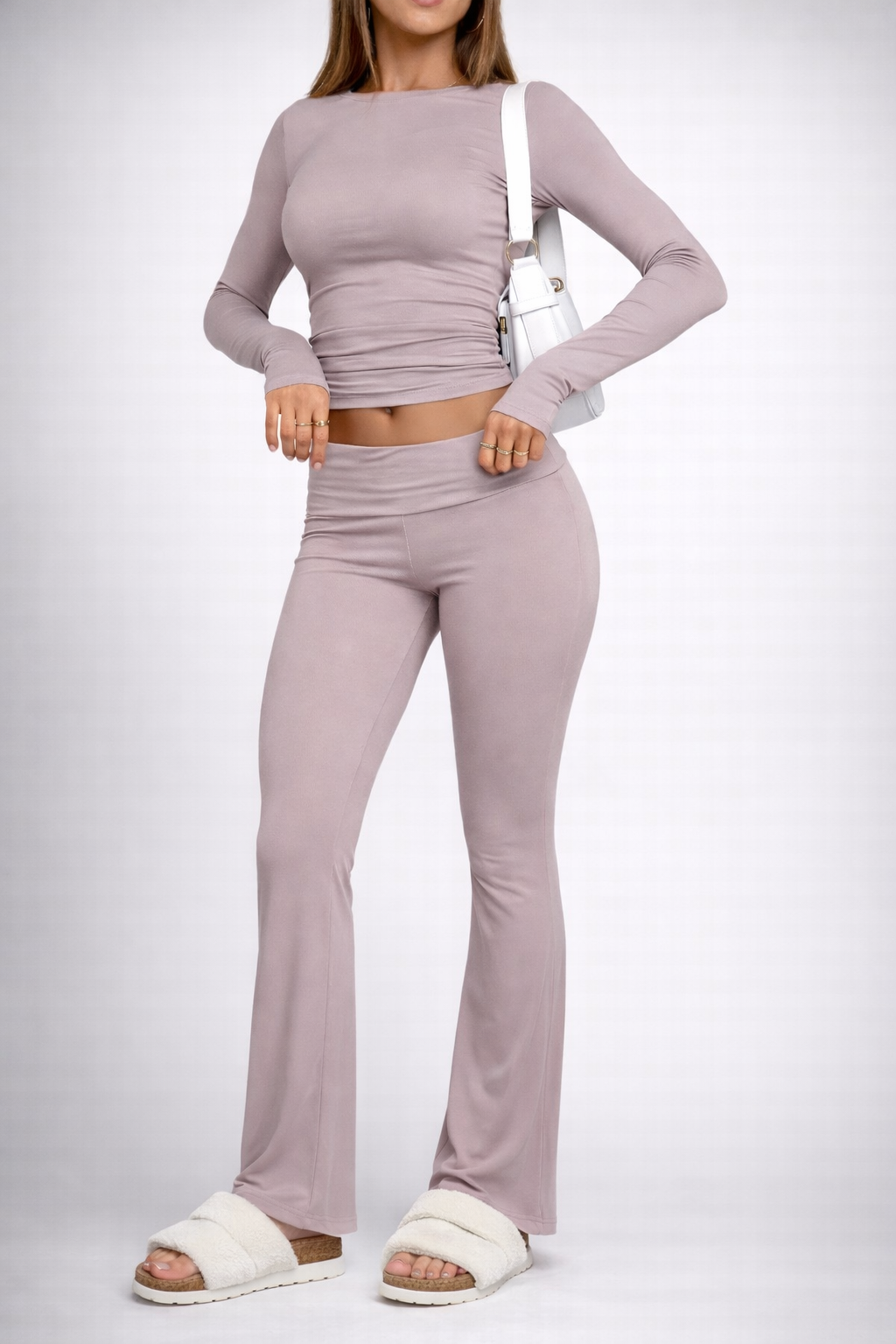 Person wearing a matching lavender long-sleeve top and flared pants on a white background
