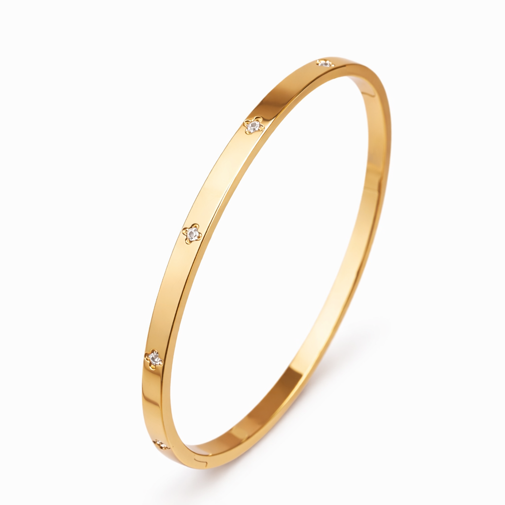 Gold bracelet with small diamonds on a white background