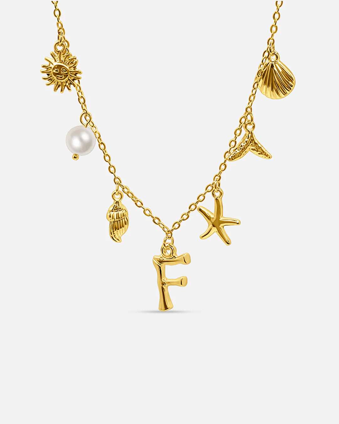 Gold necklace with various charms including a sun, shell, pearl, and starfish on a white background.