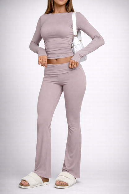 Person wearing a matching lavender long-sleeve top and flared pants on a white background