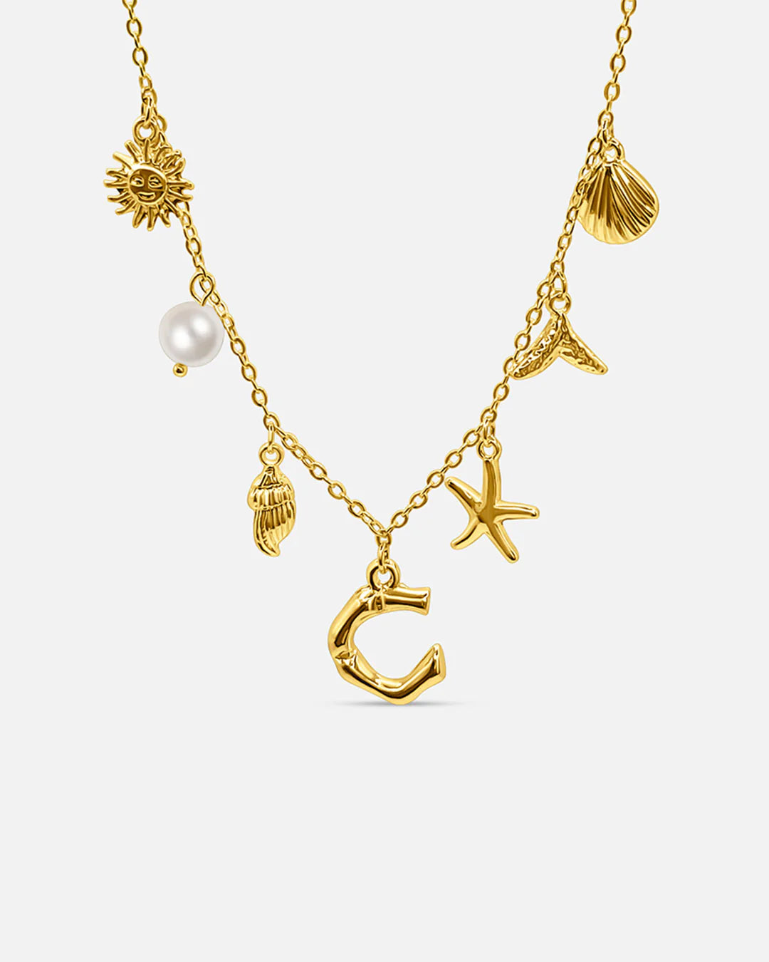 Gold necklace with various charms on a white background