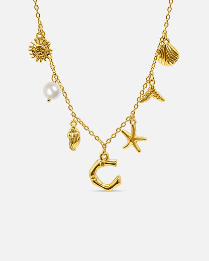 Gold necklace with various charms on a white background