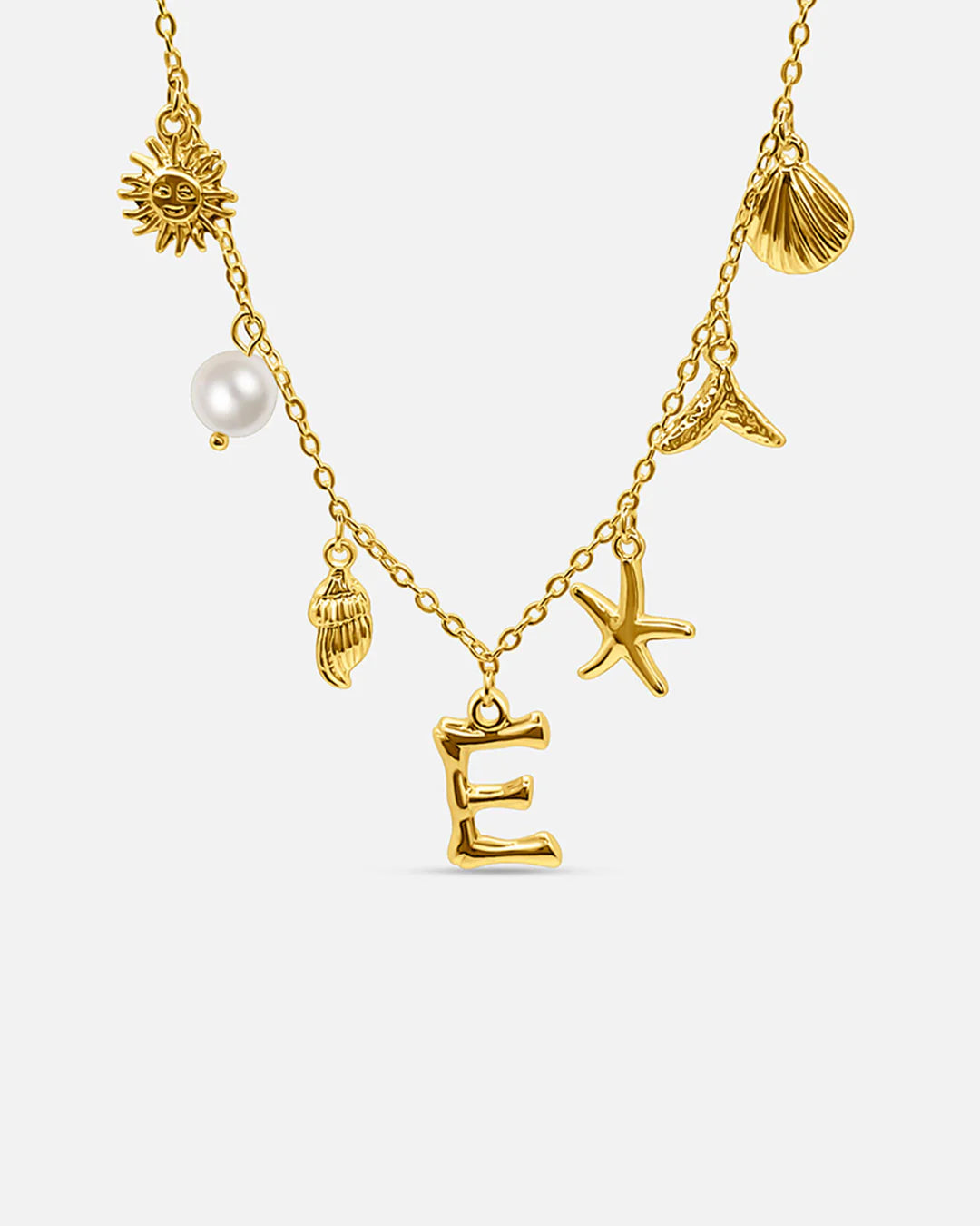 Gold necklace with various charms including a sun, shell, starfish, and letter 'E' on a white background.