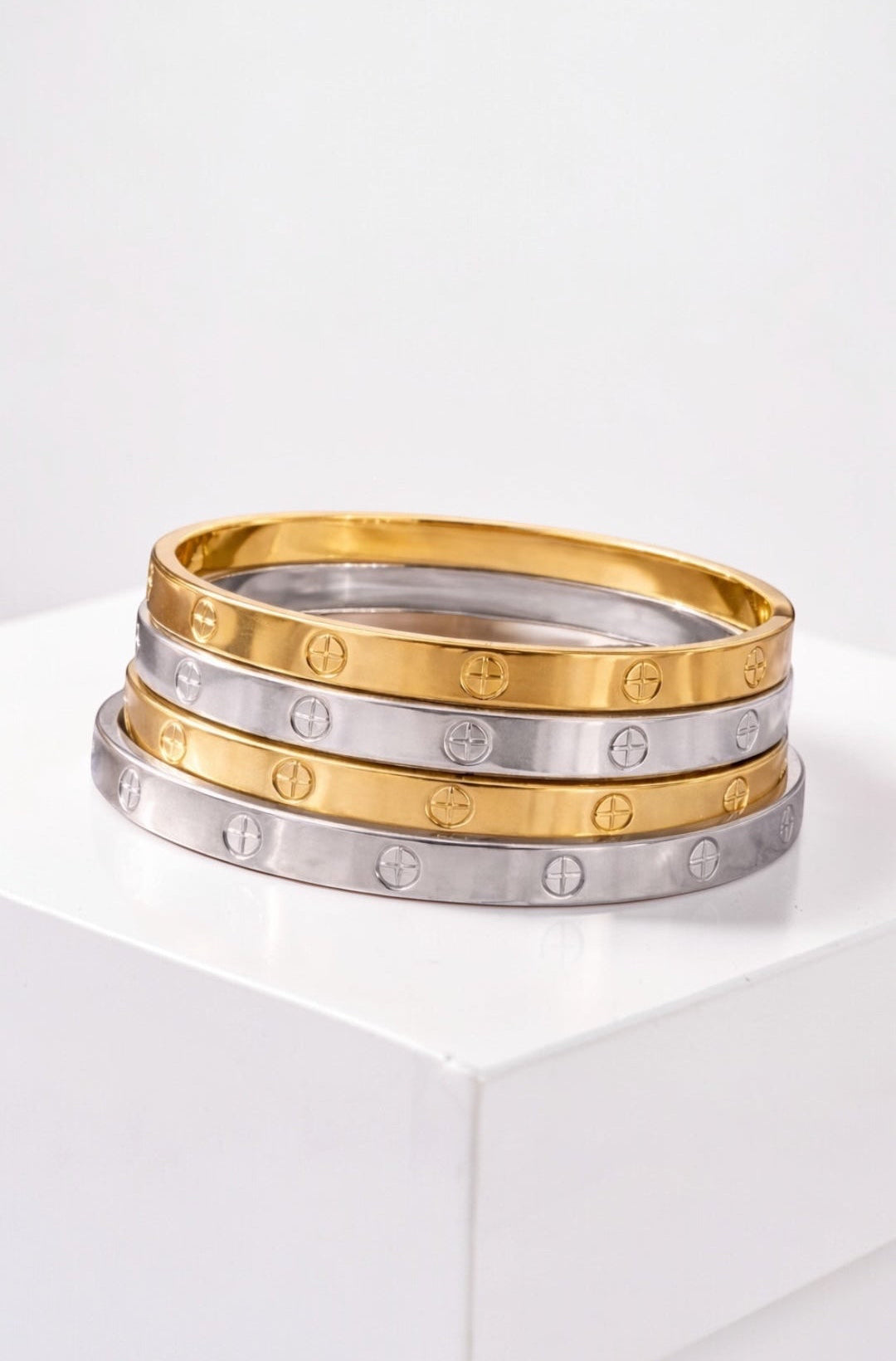 Three gold and silver rings stacked on a white surface with a white background