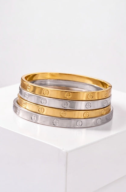 Three gold and silver rings stacked on a white surface with a white background
